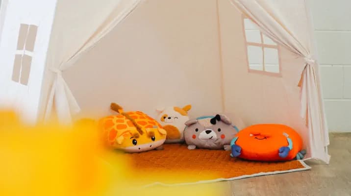 A cute play tent with plush toys set up at an event