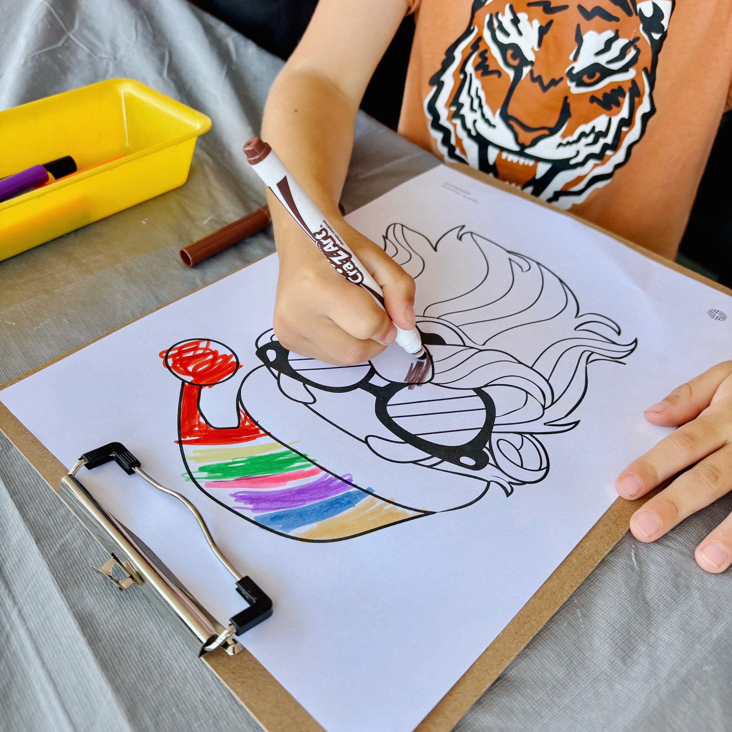Child carefully colouring a detailed illustration at an Event Sitters activity station