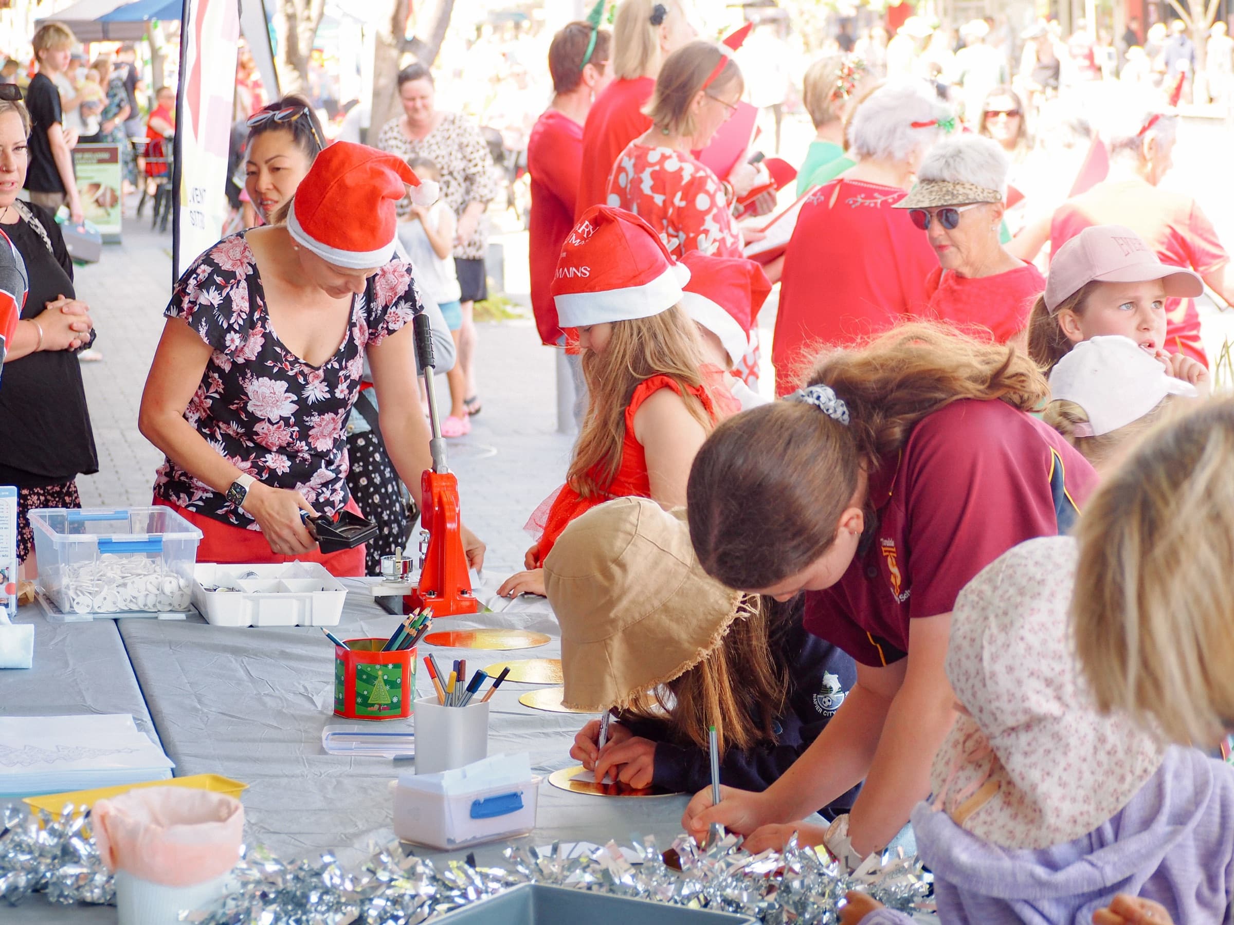 Children and parents doing Christmas crafts together at an outdoor market event